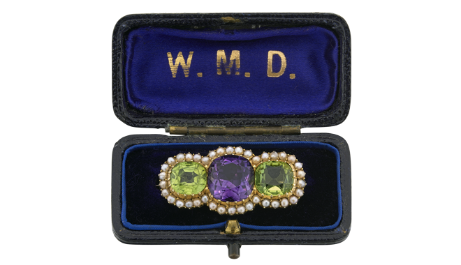 Early C20th.<br>A Gold Suffragette Brooch set with<br>an Amethyst, Peridots & Split Pearls<br>- stamped '15c' & cased